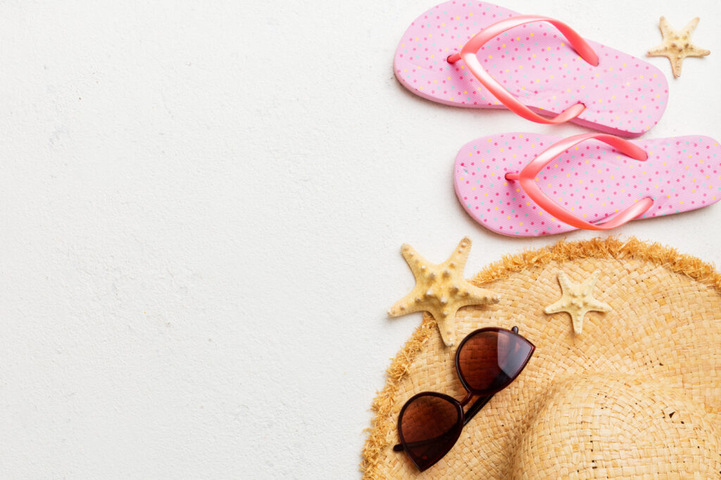 summer vacation concept flat lay. straw hat beach accessories and towel top view. space for text. travel concept